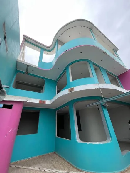 Edificio de 3 pisos en venta en Nuevo Chimbote listo para hotel u hospedaje: fachada, cochera con porton elevado, habitaciones con bano propio y terraza amplia